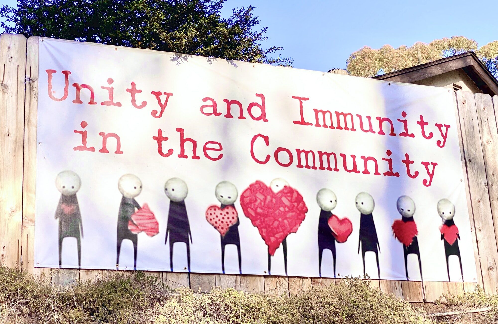 Authentic real community banner sign calling for unity and immunity in the community